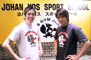 ヨハンボス　スポーツ スクールの看板の前に立つTsuyoshiとHiroshi